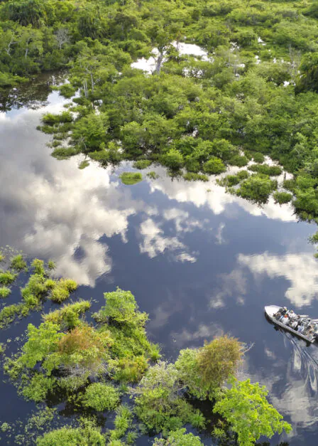 Parc national d'Odzala, République du Congo – 19 mai 2019 : vue aérienne d'un bateau à moteur transportant des touristes sur une rivière traversant la forêt tropicale du bassin du Congo, dans le parc national d'Odzala, en République du Congo.